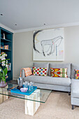 Kunstwerk über dem Sofa mit gläsernem Couchtisch London UK