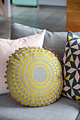 Yellow grey and pink patterned cushions on sofa in Sussex home UK