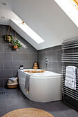 Corner bath with wall mounted radiators and skylight windows Sussex UK
