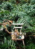 Dried flowers on wooden chair in ferns on Isle of Wight hillside UK