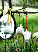 China cups tied with ribbon in woodland with mirror Isle of Wight, UK
