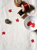 Red star shaped buttons with spools of thread on linen tablecloth Isle of Wight home UK