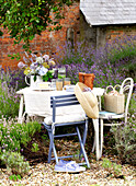 Blauer Stuhl mit Sonnenhut am Tisch im ummauerten Garten Isle of Wight, UK