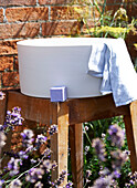 Waschschüssel mit Seife und Handtuch im ummauerten Garten auf der Isle of Wight, UK