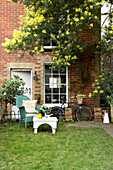 Wicker chair and table on lawn at brick exterior of Isle of Wight home UK