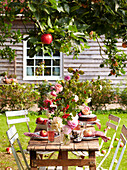 Late Summer picnic in garden with cakes fruit and flowers