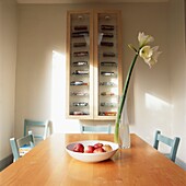 Dining room table with amaryllis flower and glass fronted cabinet