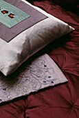 Satin cushion and quilt detail in purple tones