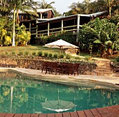 Zinndach- und Holzhaus in einem tropischen Garten mit Swimmingpool