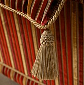 Detail of a gold coloured tassel on a cushion