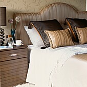 Double bed with bedside table and decorative cushions