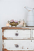 Scandinavian style bedroom with distressed paintwork and vintage bed and chest of drawers