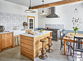 Country kitchen with island, hanging lamps and tiled splashback