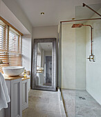 Brightly designed bathroom with free-standing washbasin and shower