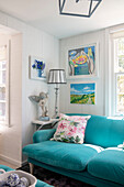 Living room with turquoise sofa and wall decorations