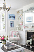 Bright living room with fireplace, chandelier and antique toys