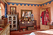 Orientalisch inspiriertes Schlafzimmer mit verzierten Holzmöbeln und bunten Textilien