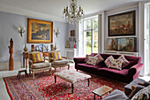 Elegant lounge with upholstered furniture, antiques, and collection of paintings
