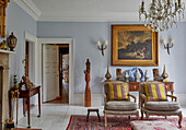 Lounge with upholstered armchairs, antiques, and works of art