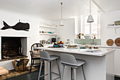 Kitchen with fireplace, kitchen island and mint green tiles