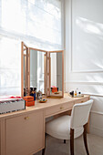 Dressing table with three-piece mirror and upholstered chair below window
