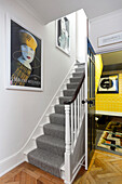 Hallway with staircase, art posters and parquet flooring