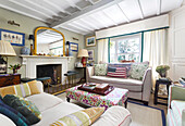 Living room with fireplace, patterned textiles and mirror