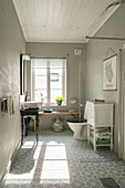 Badezimmer mit freistehender Badewanne und ornamentalem Bodenfliesen-Design