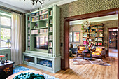 Living room with bookshelf, parquet flooring and leopard print wallpaper