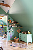 Children's room with wall shelves, toys and mint green wall paint