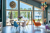 Bright dining area with a view of the water and colourful designer chairs