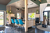 Modern kitchen interior with blue bar stools and plants