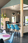 Modern kitchen with bar stools in blue and plant decorations