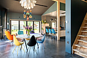 Modern dining area with colourful chairs and pendant lights