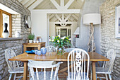 Country-style dining room with natural stone wall and wooden furniture