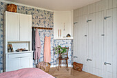 Bedroom with patterned wallpaper and fitted wardrobes