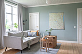 Living room with grey sofa, wall map and wooden furniture