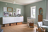 Living room with white sideboard, wooden boxes and vintage decorations