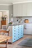 Country kitchen with white cabinets, kitchen island and dining table