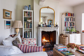 Traditional living room with fireplace, bookshelves and striped sofa