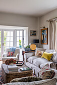 Helles Wohnzimmer mit gemusterten Textilien und Dekokissen auf einem Sofa