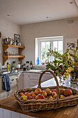 Wooden worktop and wicker basket full of apples