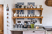 Kitchen shelf with crockery and coffee pots, Spanish tiles as splashback
