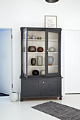 Display cabinet with ceramic vases in a minimalist room