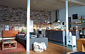 Modern kitchen and seating area with mid-century furniture in loft with brick wall