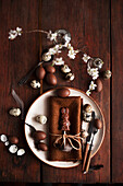 Easter place setting with brown cloth napkin, chocolate Easter bunny, chocolate eggs, and quail eggs