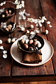 Easter place setting with brown cloth napkin, bowl with chocolate eggs, and quail eggs