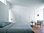 King-size bed in light bedroom with built-in wardrobes