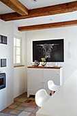 Room with wooden beams, tiled floor, counter and bar stools