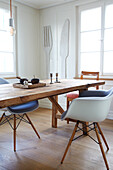 Wooden table with modern chairs and XXL cutlery as wall decoration in the dining room